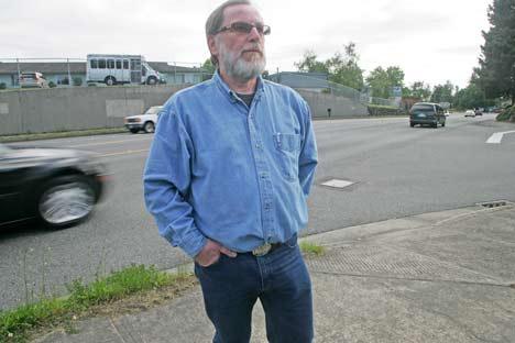 Panther Lake resident John Gehlman stands along the Benson Highway June 18 during rush-hour traffic as he talks about the dangerous jaywalking he has seen along the busy roadway.