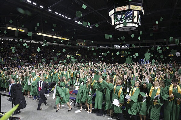 Kentridge High School graduates throw their caps in the air in celebration at the end of their commencement ceremony last Saturday at the ShoWare Center.