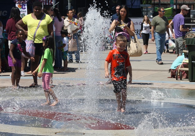 Kids play in the water June 22 at Town Square Plaza in Kent. Temperatures could hit record highs over the next several days.