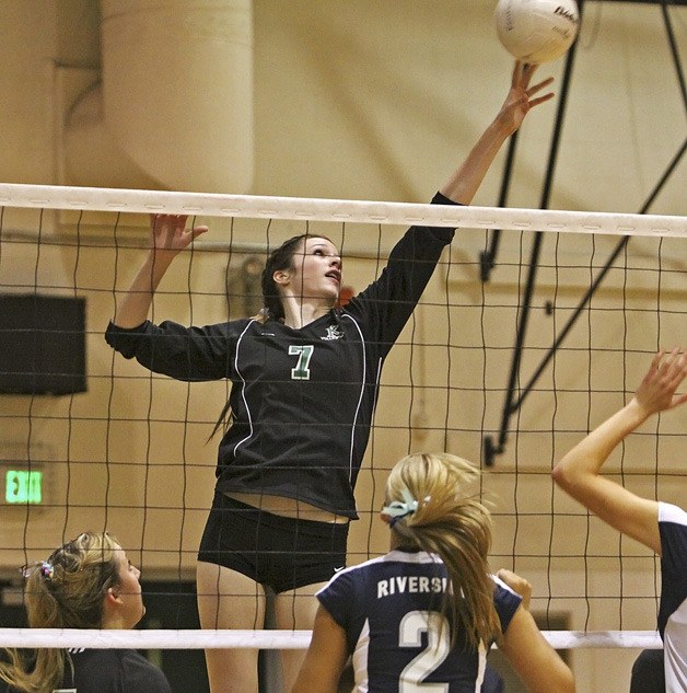 Kentwood's Lauren Hacket tips the ball over for a kill
