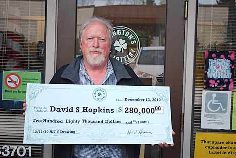 Lottery winner David Hopkins of Des Moines poses Dec. 13 with his giant check