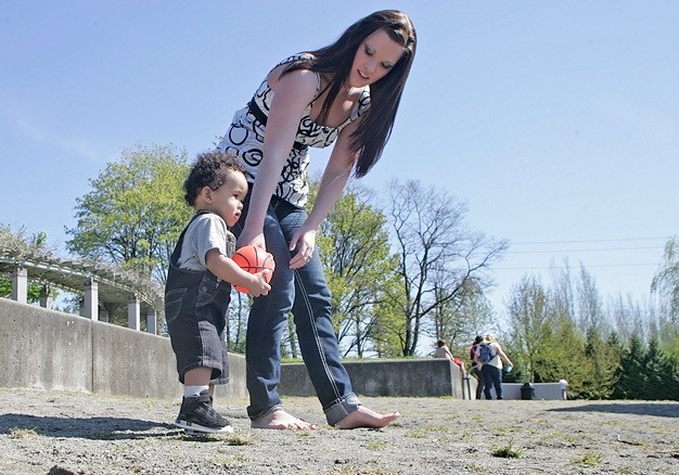 Ashley Vorderbrueggen and her son Mario Allen Jr. play on the shores of Lake Meridian last month and enjoy the sunshine. Volunteers are wanted June 25 to help finish off installation of a new playground at the park.