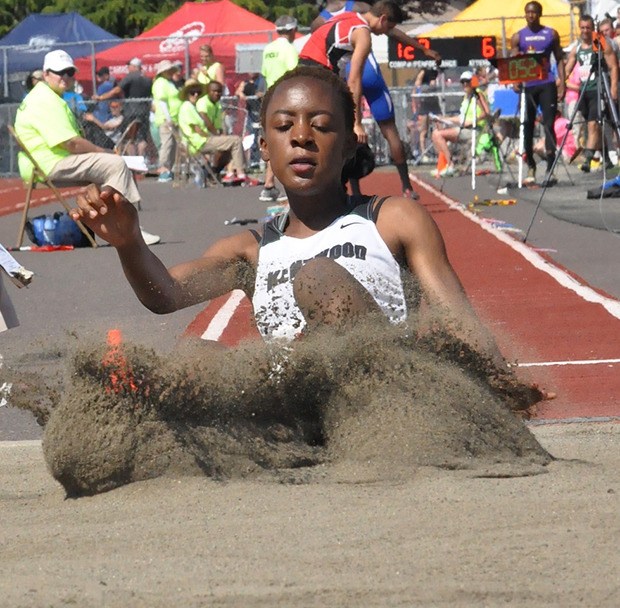 Kentwood's Brittany Woke leaps a personal-best 18-0¼ to capture the 4A state long jump title Friday.