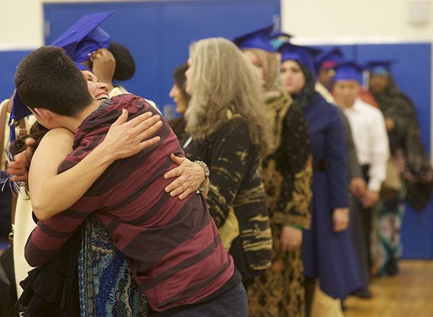 A mother and son embrace as she waits to receive her PASA diploma during graduation ceremonies at the Kent-Meridian gym on Dec. 16.