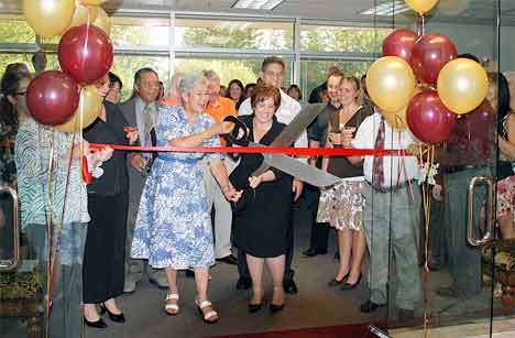 Kent Mayor Suzette Cooke helps attorney Lisa Voso cut the ribbon Wednesday during an open house at Voso's new law office