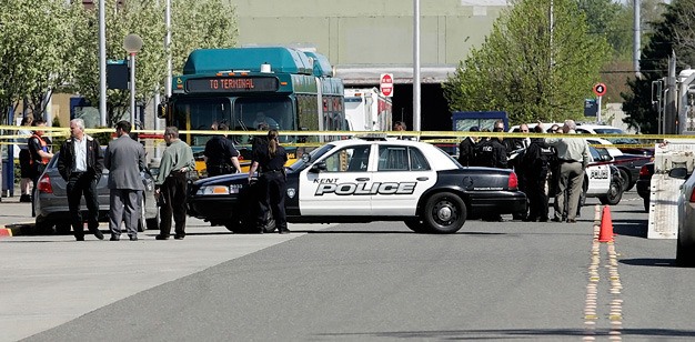 Kent Police investigate the shooting of an armed man Wednesday by police officers at the Kent Transit Center.