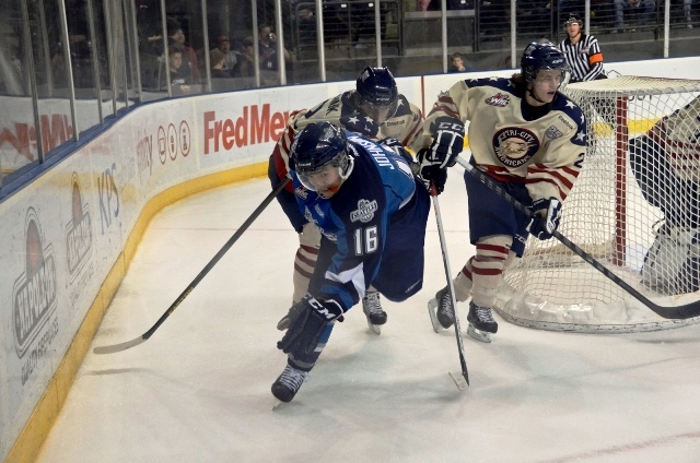 The T-Birds' Andrew Johnson scrambles for the puck behind the Americans' net.