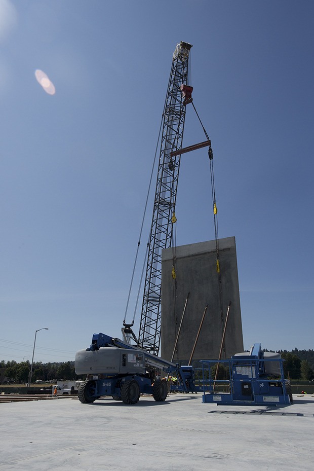 Construction crews hoist the first of many 24-by-60-foot wall panels for the new 800