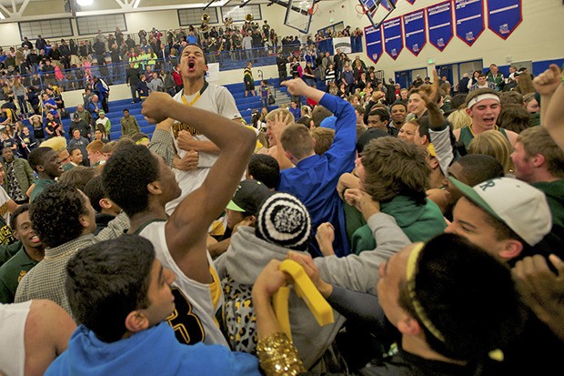Kentridge guard Deon Thomas exults as fans storm the basketball court at Kent-Meridian High School after the Chargers’ state-clinching 65-61 victory over Arlington in a 4A regional playoff last Friday night.