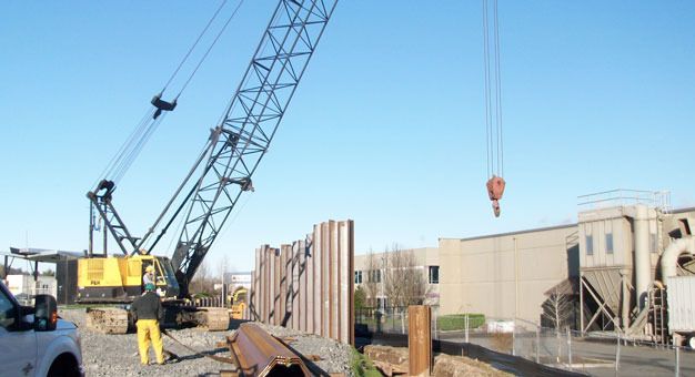 Crews install a metal sheet pile flood wall in January at the Boeing Levee along the Green River in Kent similar to the city's proposal for the Briscoe-Desimone levee repair.