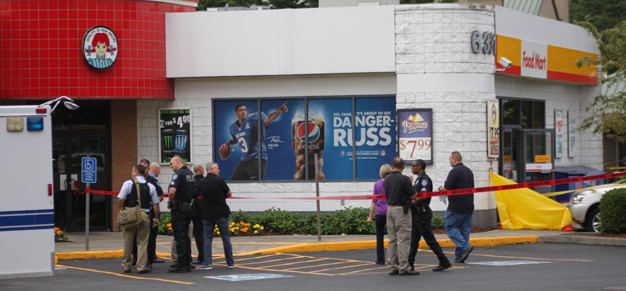 Kent Police investigate in August 2014 the shooting deaths of two Shell station employees. A jury on Tuesday convicted Leland Russell Jr. on two counts of first-degree murder for the killings.