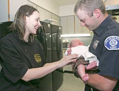 Kent Fire Fighter Bob Tonda takes baby Connor from his mom Cindy Wayner during their visit at Station 75 Thursday