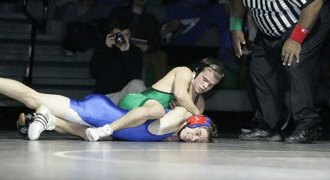 Kentwood’s Hayden Peterson (top) holds down K-M’s Alec Moss during Wednesday night’s 119-pound match. Peterson hadn’t wrestled in more than two weeks due to a mild concussion he suffered during a tournament. The Kentwood junior returned strong