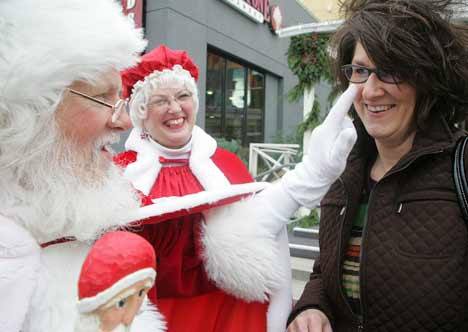 Santa Claus and  Mrs. Claus give Debra Brewer the naughty or nice test before she and her family went to Santa’s house for photos last November at Kent Station. Santa’s House will open this weekend at the retail shopping complex