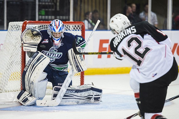 The Cougars' Jansen Harkins fires a shot at T-Birds goalie Logan Flodell. The 17-year-old Flodell stopped 37 of 40 shots in his season debut for Seattle.