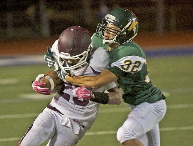 A Kentridge defender tries to bring down a South Kitsap ball carrier during Thursday night's action.