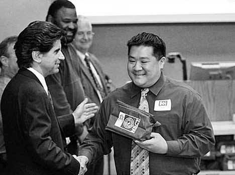 Kentwood High School teacher Jay Maebori receives a congratulatory handshake from Kent School Superintendent Edward Lee Vargas during the Kent School Board's Feb. 24 meeting