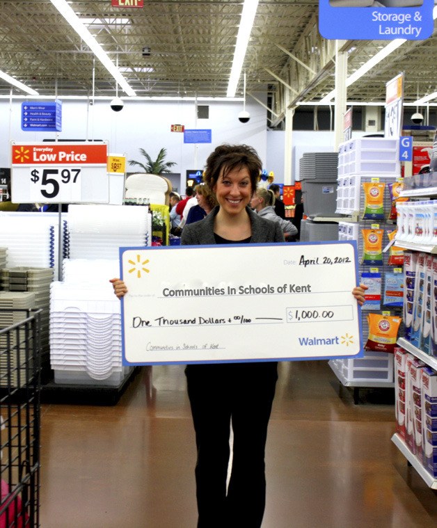 A representative from Communities in Schools of Kent collects a grant given by the Walmart in Covington.