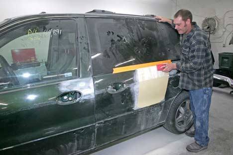 Collision technician Kevin Johnson works Nov. 4 on the van that will be donated to Food Lifeline at Precision Collision Auto Body.