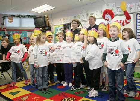 Chris Knutkowski and her first-grade class pose as a group with their Teacher of the Week t-shirts on and with Star 101.5 radio host Curt Kruse along with Ronald McDonald.
