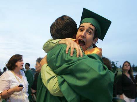 A Kentridge graduate grabs a classmate following commencement last year at the Kent ShoWare Center. This year the center will be the venue for a number of graduations