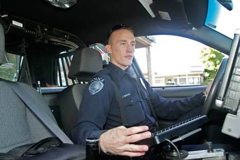 Kent Police Officer David Beerbower works in his police cruiser. Kent Police say they aren't doing emphasis patrols on the new cell-phone law at this time