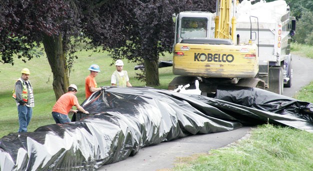 Crews place giant sandbags in 2009 along the Green River in Kent near the Riverbend Golf Complex. The cities of Kent
