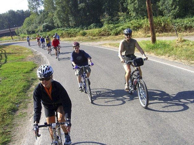 Bicyclists ride past the Green River Natural Resources Area.