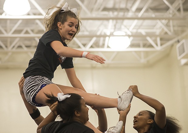 Kent-Meridian cheerleader Mikayla Thomas takes a fall as she practices her stunts with Tabitha Velasquez