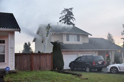 Kent firefighters work to douse a house fire in the 9800 block of South 242 Place on Monday afternoon.