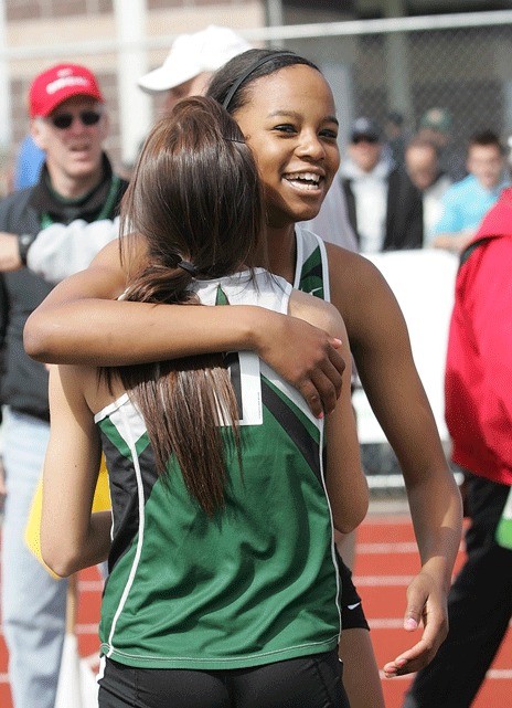 Kentwood's Madelayne Varela hugs teammate Holly DeHart after the Conquerors captured the gold medal in the 4 x 200 relay. DeHart ran the third leg