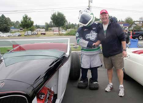 Kent Police officer and event coordinator Hans Mak poses with Coolbird besides a Ford roadster at the second annual Greg Duffin Car and Motorcycle Show July 31 in Kent.