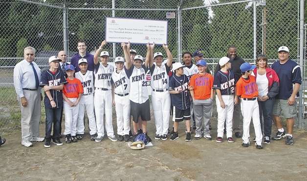 Kent's 2011 Little League All-stars receives the ceremonial check from Farmers Insurance and 710 ESPN donation for field improvement at Ryan Brunner Park Field Friday