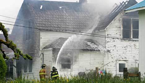 Kent firefighters extinguish a residential fire May 15 on 116th S.E. in Kent. The Kent Fire Department may in the future be merged with Fire District 37