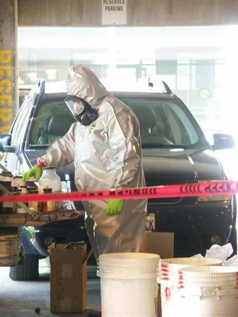 Investigators examine chemicals found Tuesday in the back of a pickup parked in the parking garage next to Kent City Hall.