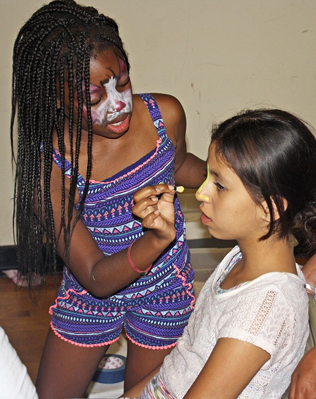 Girls face paint each other during a National Night Out event Tuesday night at the Kent Phoenix Academy.