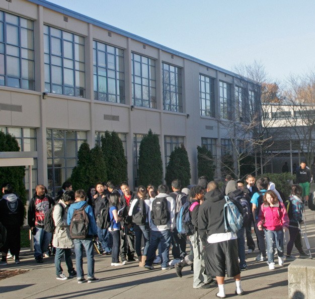 The Kent School District expects to cut about 30 employees from the 2011-12 budget. Students gather (above) outside of Kent-Meridian High School.