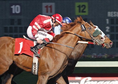 Mr. Mad Max and jockey Deborah Hoonan-Trujillo catch Chaching Pete in the final stride of the Facebook Friday Purse.