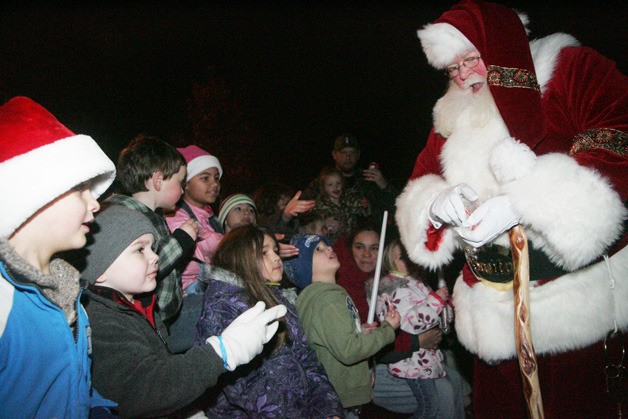 Santa hands out candy canes to the kids before the tree lighting