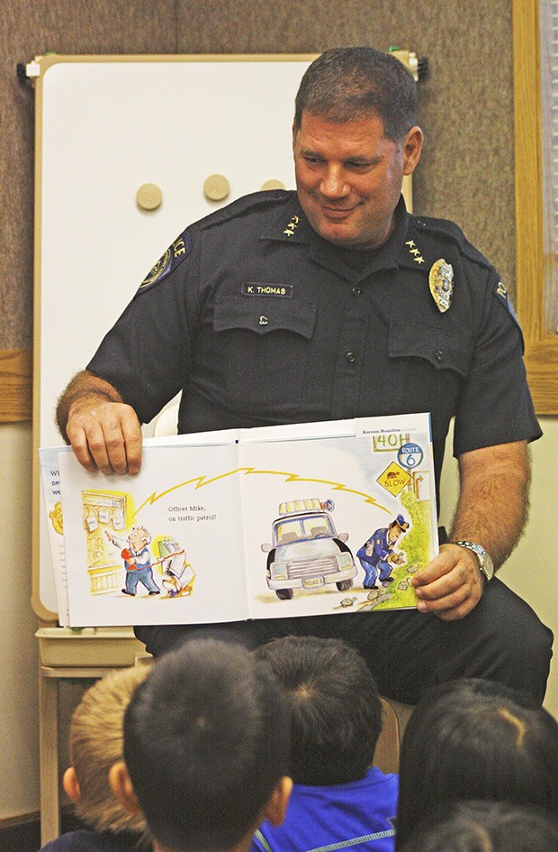 Kent Police Chief Ken Thomas shares a tale with children at Sunrise Elementary.