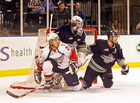 Seattle Thunderbirds goalie Calvin Pickard and defender Jeremy Schappert hold back Tri-City Americans player Brett Plouffe from making a gap in the goal