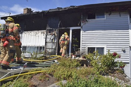 Kent firefighters mop up a house fire in SeaTac on Tuesday.