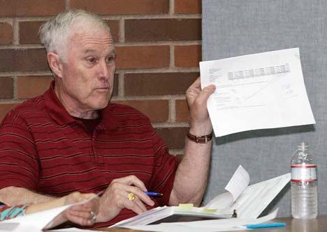 Kent City Council member Ron Harmon holds up the budget and questions Chief Administrative Officer John Hodgson on an item during a Council workshop on city finances Tuesday.