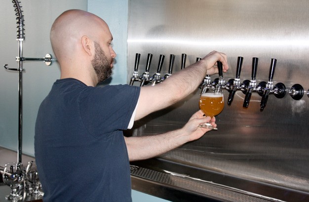 Bartender Jeremy Belt pours a beer at the Airways Brewing new brewery and tap room in Kent at 8611 S. 212th St.
