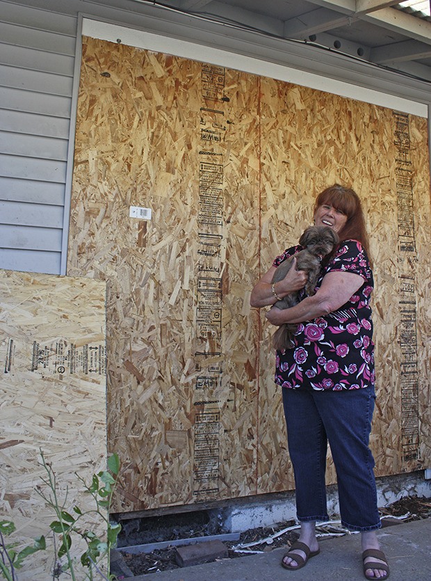 Renee Keller – with her dog Pixie – surveys the damage after a man drove his truck into the front window of her East Hill home early Thursday morning. Damage is around $4