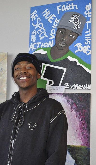 Kent-Meridian High School senior Kevin Watkins III stands by a self-portrait he painted in his International Baccalaureate art class. Watkins' painting is one of many pieces of art created by Kent School District students