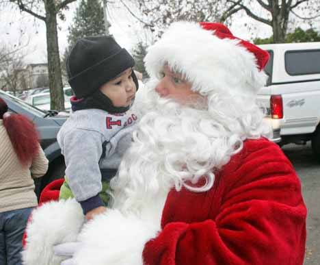 Toddler Benjamin Lizar got a moment with Kent Fire Department's Santa last December as the Jolly Old Elf makes his arrival at the Kent Food bank to drop off nearly 5000 toys in last year's Toys for Joys event.
