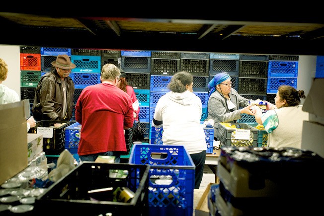 Volunteers hand out food last year for Thanksgiving dinners at the Kent Food Bank. Cash and food donations from the Kent Turkey Challenge provided the items.