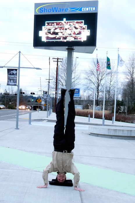 Kent City Councilman Dennis Higgins stands on his head to help promote the ShoWare Center's Marquee Tickets Contest.