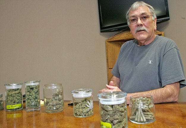 Charles Lambert displays dried marijuana July 26 at his reopened Kent business called Evergreen Association of Community Gardens.